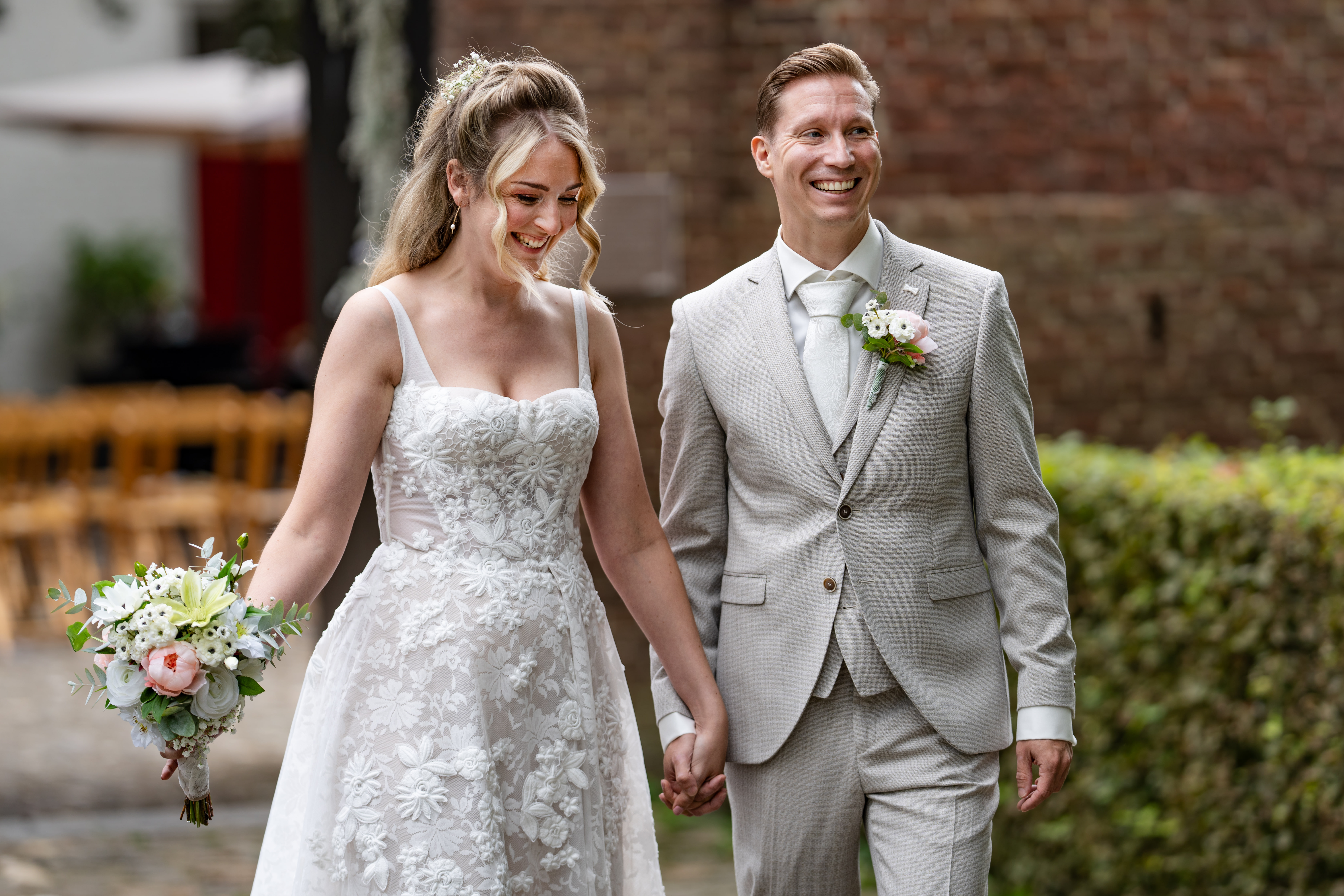 Mathijs en Chantal lopen lachend hand in hand na de ceremonie